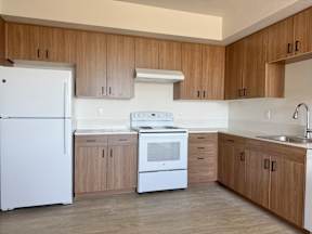 A kitchen with wooden cabinets and white appliances.