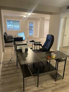 A room with a desk, chair, and laptop.