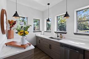 a kitchen with a sink and three windows