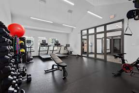 a gym with treadmills and other exercise equipment in a building with glass doors