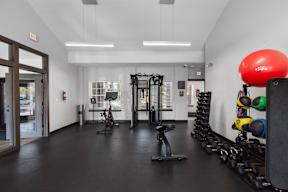a workout room with weights and a large red ball on the floor