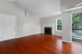 an empty living room with wood floors and a fireplace