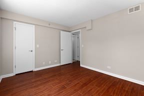 an empty living room with wood floors and white walls