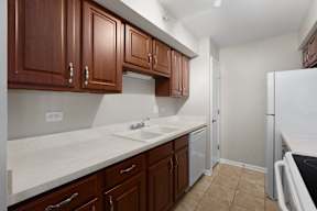 a kitchen with wooden cabinets and a sink and a refrigerator