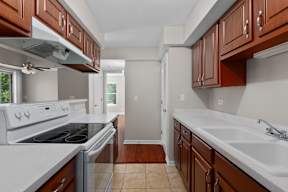a kitchen with wood cabinets and white counter tops and a stove top oven