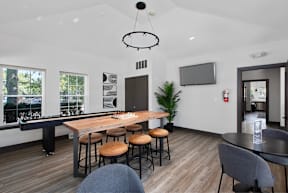 a living room with a bar and a table with stools