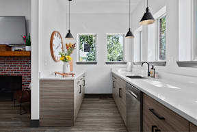 a kitchen with wooden cabinets and white counter tops and a sink