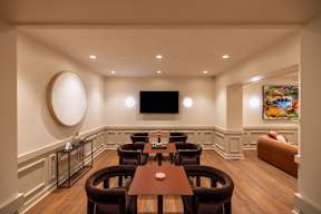 The community room at The Belle featuring a seating area beside a wall-mounted television.