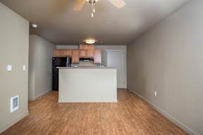 A kitchen with a white counter and wooden floors.