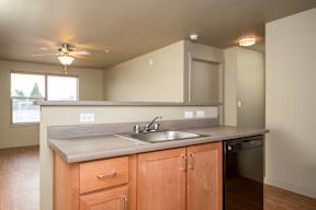 A kitchen with wooden cabinets and a stainless steel dishwasher.