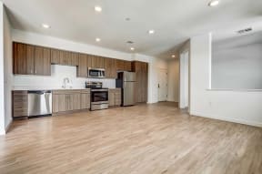 Livermore Apartments | Ageno | Kitchen Area with Quartz Countertops, Dark Stained Wooden Cabinets, and Stainless-Steel Appliances