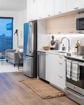 Studio kitchen with stainless steel appliances and white granite countertops