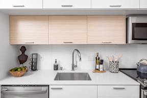 Kitchen with stainless steel appliances, white granite countertops and light colored wood cabinets