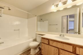 Vacant apartment home bathroom with sink and vanity and tub/shower combination. 