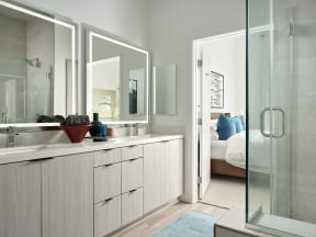 a bathroom with a sink and a shower and a bedroom