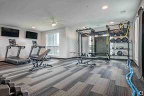 A spacious fitness center with treadmills, exercise bikes, and weightlifting equipment  located at Deforest Yards in DeForest, WI