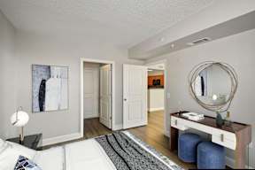 A modern bedroom with a large bed and vanity