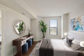 A bedroom with a large bed and vanity