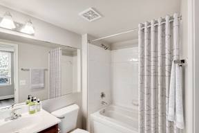 A white bathroom with a bathtub.