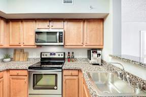 A kitchen with wooden cabinets and a stove top oven