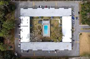 Aerial view of a parking lot with a pool in the middle.