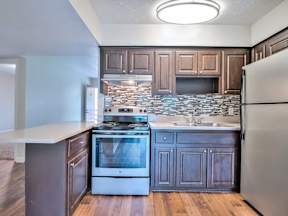 Kitchen with a stove, sink, and refrigerator.