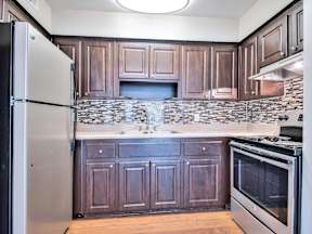 Kitchen with dark wood cabinets and a black refrigerator.