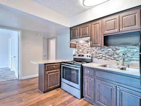 Kitchen with wooden cabinets and a stone backsplash.