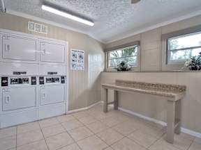Laundry room with washers and dryers and a bench.