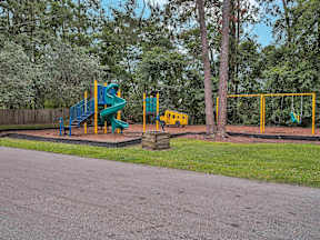 Playground with a blue slide and yellow swings.