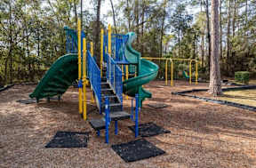Playground with a green slide and a blue and yellow structure.