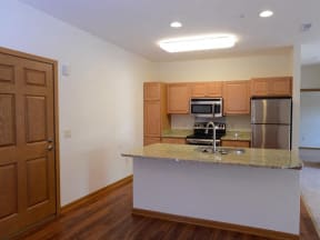 Gourmet Kitchens with Islands, Caesarstone Countertops, and Decorative Backsplash at The Highlands at Mahler Park Apartments 55+, Wisconsin
