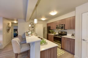 Kitchen with Countertop, Elevated Cushioned Chairs, Wood Inspired Floor, Oven, Wood Cabinets, Ceiling Lights