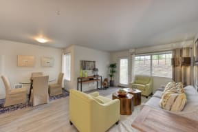 Dining Area with Wood Inspired Floor, Lime Green Chairs, Grey Sofas/ Chairs, Open View Windows, Brown Decorative Tables with Fruitbowl