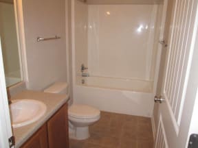 large bathroom with tub, toilet, and bathroom