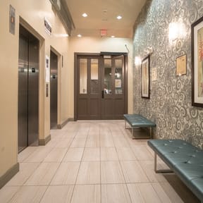 A hallway with a bench and two doors.