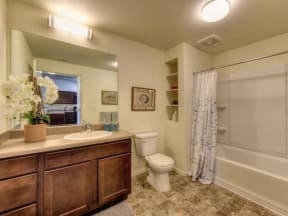 Apartment For Rent In Chico, California - Bathroom With Shower And Tub, Tile Flooring, Large Mirror With Counter Space, And Toilet
