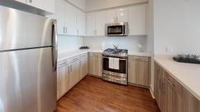 Modern kitchen with stainless steel appliances - The Roy Apartments
