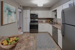 spacious kitchen with stainless steel appliances and a bowl of fruit on the counter
