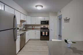 large kitchen with white cabinets and stainless steel appliances