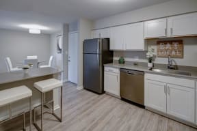 kitchen with white cabinets, stainless steel appliances, and island seating