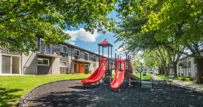 red swing set outside of Axis at Westmont Apartments