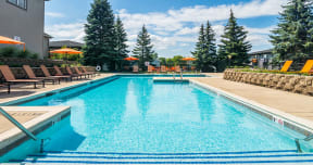 large outdoor swimming pool surrounded by orange lounge chairs