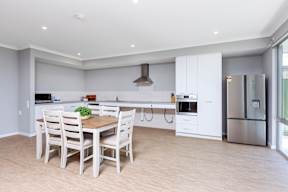 A modern kitchen with a dining table and chairs.