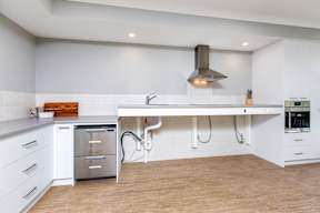 A modern kitchen with a stainless steel dishwasher and white cabinets.