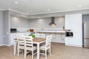 A modern kitchen with a dining table and chairs.