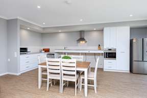 A modern kitchen with a dining table and chairs.