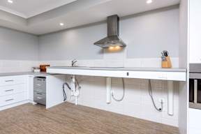 A modern kitchen with a white countertop and a stainless steel range hood.