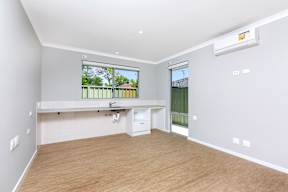 A room with a window and a white wall.