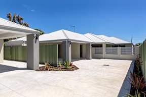 A modern house with a white roof and grey walls.